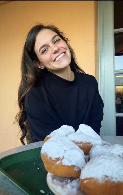Callie Scull sitting behind plate of beignets