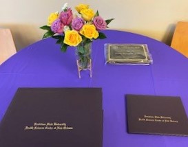 Image of flowers, an award, and diploma covers on a table